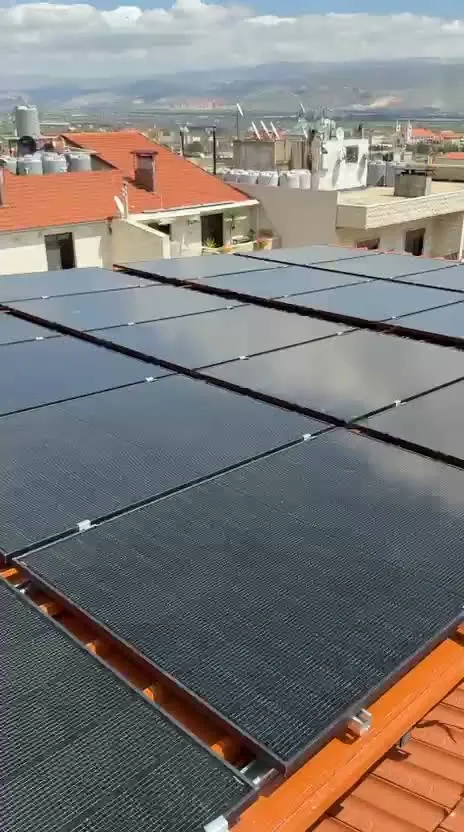 Schwarze Solarmodule auf einem Dach in Zahlé, im Hintergrund die Bekaa-Ebene und Berge